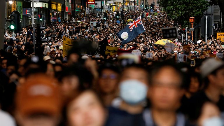 Le drapeau colonial de Hong Kong est tenu en l'air lors d'une marche des manifestants