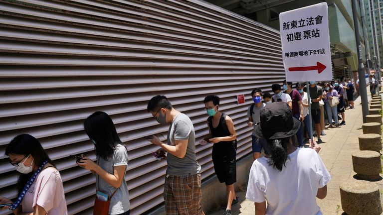 Les gens portant des masques faciaux ont fait la queue pour voter dans la chaleur 33C