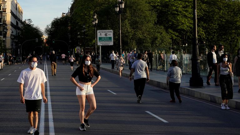 Des personnes portant des masques faciaux marchent le long d'une rue, alors que la propagation de la maladie à coronavirus (COVID-19) se poursuit, à Madrid, Espagne, le 3 mai 2020