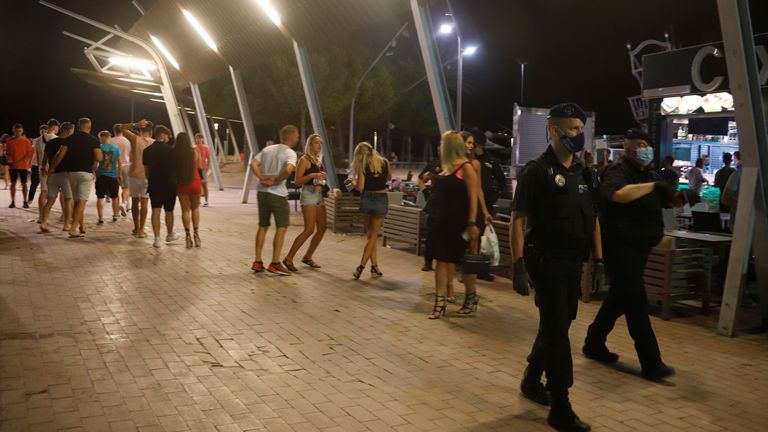 Des policiers portant des masques de protection patrouillent dans la rue Punta Ballena à Magaluf