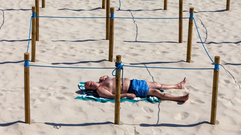 Un homme prend le soleil dans un endroit isolé désigné sur une plage à Sanxenxo, Galice, Espagne