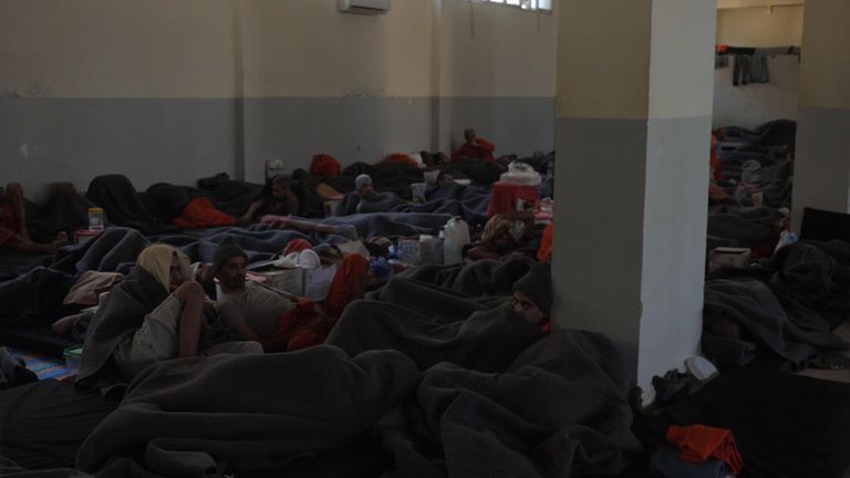 Des dizaines de prisonniers sont coupés dans une grande pièce, tandis que d'autres sont en groupe dans des cellules