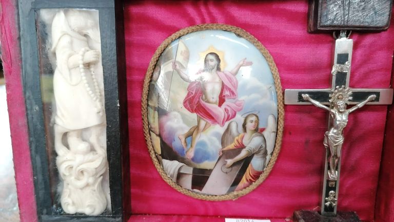 Un loup en robe, un crucifix et une photo de la résurrection du Christ figurent parmi les objets de la boîte
