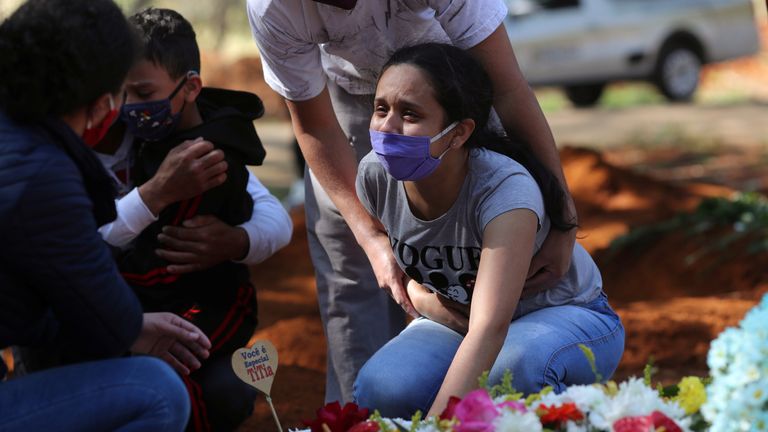 Une femme pleure sa mère, décédée des suites d'un coronavirus présumé, lors d'un enterrement à Sao Paulo