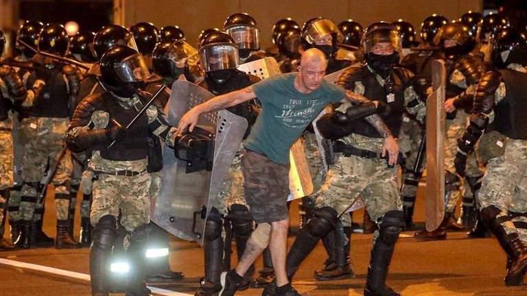 Des agents des forces de l'ordre escortent un homme lors d'affrontements avec des partisans de l'opposition après la clôture du scrutin lors de l'élection présidentielle à Minsk, Biélorussie, le 9 août 2020