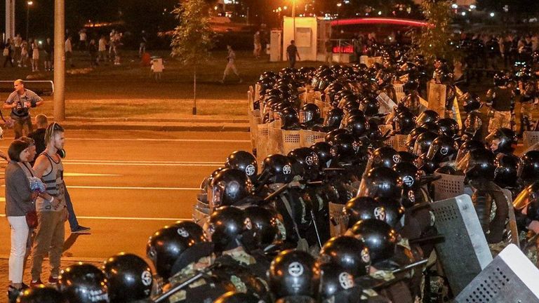 Les partisans de l'opposition restent devant des officiers bloquant une rue