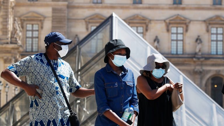 Des personnes portant des masques de protection se promènent près du musée du Louvre