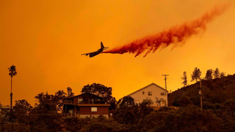 Un avion fait une chute de retardateur au-dessus des maisons dans la région de Spanish Flat de Napa, en Californie, lors de l'incendie de Hennessey le 18 août 2020. - Aux heures tardives du 18 août, l'incendie de Hennessey a fusionné avec au moins 7 incendies et est maintenant appelé les incendies du complexe Lightning LNU.  Des dizaines d'incendies sont incontrôlables dans le nord de la Californie alors que les ressources en feu sont dispersées.  (Photo par JOSH EDELSON / AFP) (Photo par JOSH EDELSON / AFP via Getty Images)