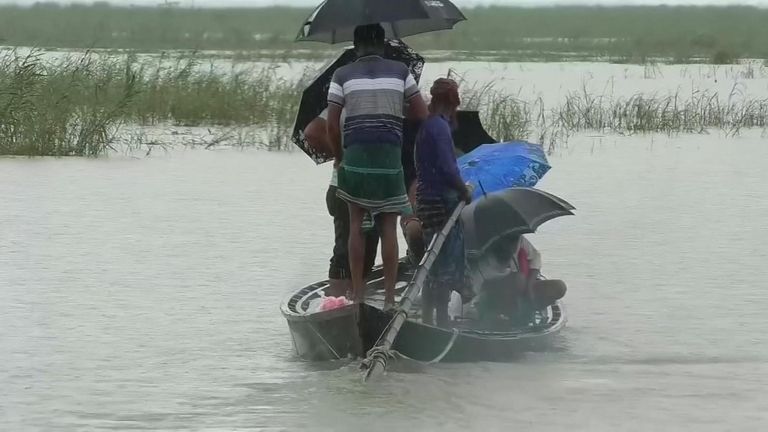 Des gens utilisent un canoë pour échapper aux eaux de crue au Bangladesh