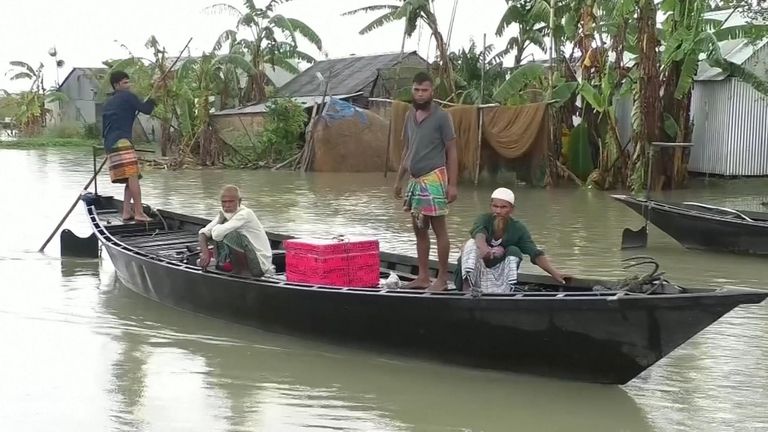 Une famille évacue son domicile par bateau lors des inondations au Bangladesh