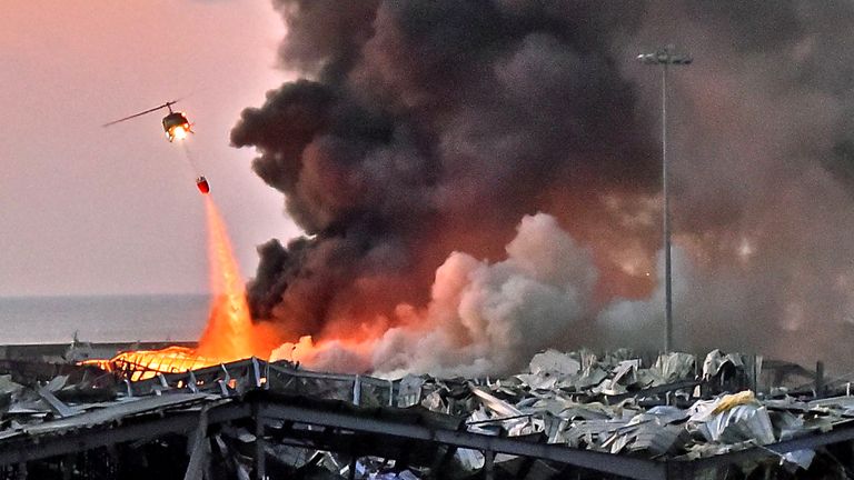 NOTE DE LA RÉDACTION: Contenu graphique / Un hélicoptère éteint un incendie sur les lieux d'une explosion dans le port de Beyrouth, la capitale libanaise, le 4 août 2020 (Photo de STR / AFP) (Photo de STR / AFP via Getty Images)