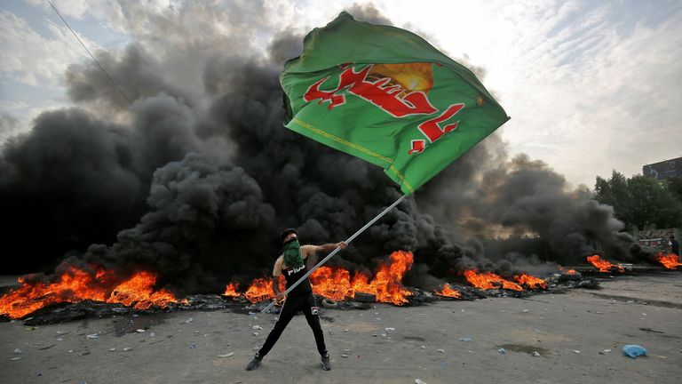 Un manifestant irakien agite un drapeau montrant le slogan musulman chiite en arabe en 2019