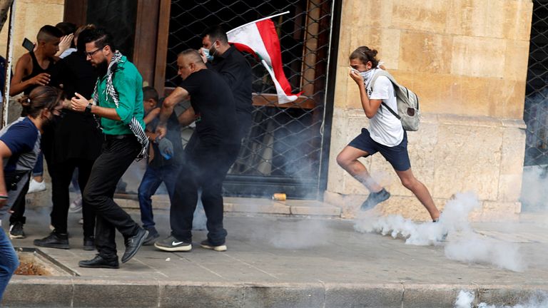 Les manifestants fuient les gaz lacrymogènes tirés par la police anti-émeute