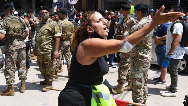 Une femme blessée a protesté contre le gouvernement alors qu'Emmanuel Macron visitait l'un des quartiers les plus touchés