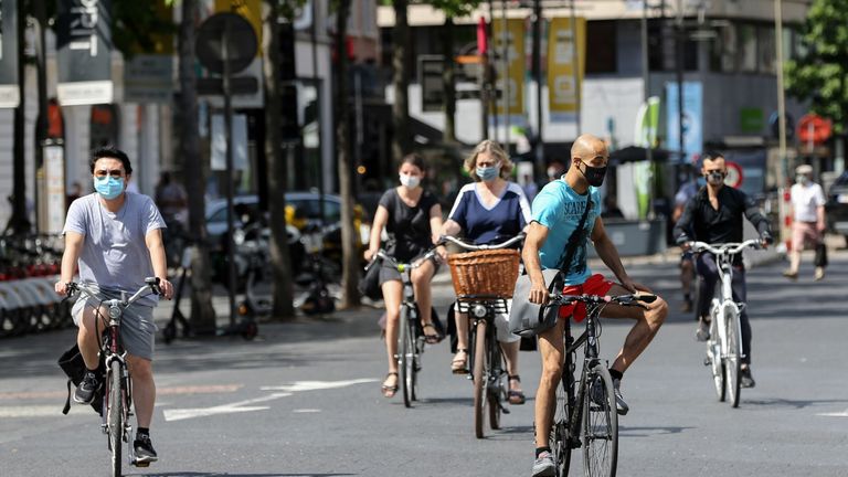 Les cyclistes portent des masques faciaux à Anvers après le durcissement des mesures de verrouillage