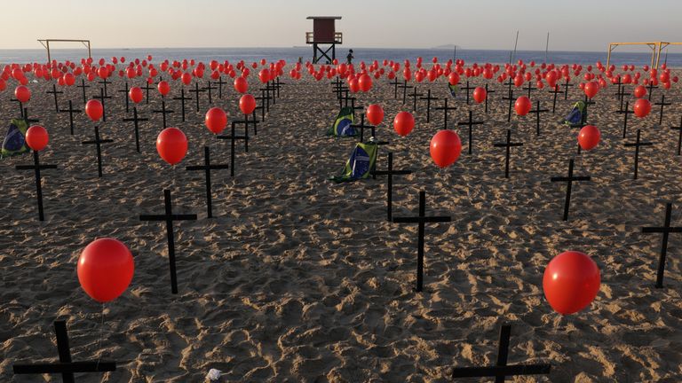 Une femme passe devant des croix et des ballons placés par des membres de l'ONG Rio de Paz en hommage aux cent mille victimes mortelles de la maladie à coronavirus (COVID-19) dans le pays, sur la plage de Copacabana à Rio de Janeiro, Brésil 8 août , 2020. REUTERS / Ricardo Moraes TPX IMAGES DU JOUR
