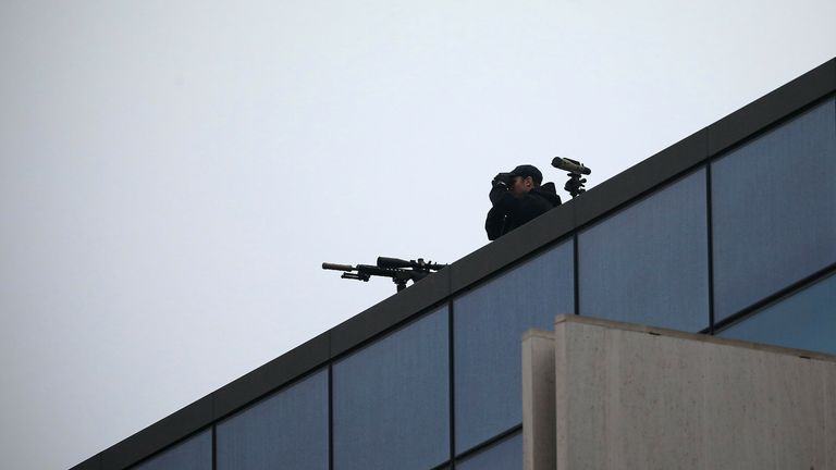 Un tireur d'élite de la police surveille les environs depuis le toit du bâtiment de la Haute Cour de Christchurch avant le premier jour des quatre jours de l'audience de détermination de la peine du suprémaciste blanc australien Brenton Tarrant à Christchurch