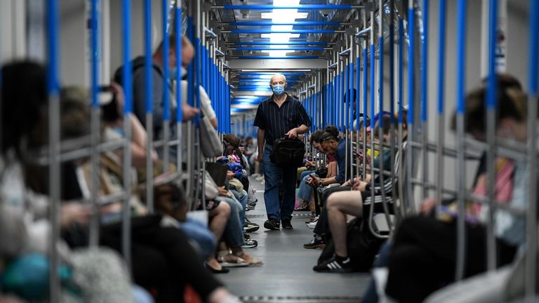 Les gens portent des protections faciales à l'intérieur d'une rame de métro de Moscou
