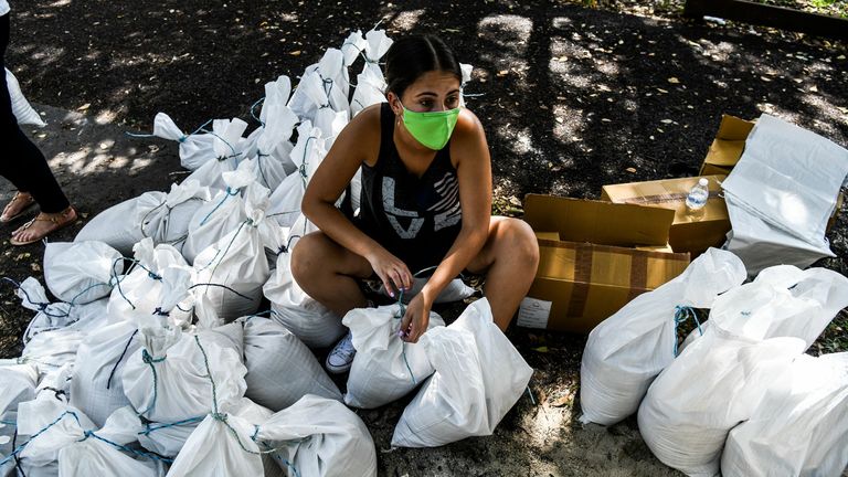 Une femme prépare des sacs de sable pour la distribution aux résidents de Palmetto Bay près de Miami