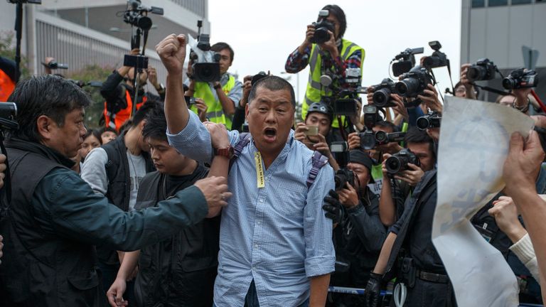 Le propriétaire du journal Tycoon et Apple Daily, Jimmy Lai, crie un slogan avant d'être emmené par un policier dans une zone précédemment bloquée par des partisans pro-démocratie, devant le siège du gouvernement à Hong Kong, le 11 décembre 2014. Les autorités de Hong Kong ont commencé jeudi à nettoyer le principal site de protestation en faveur de la démocratie qui a obstrué les routes dans le quartier le plus important économiquement et politiquement de la ville pendant plus de deux mois dans le cadre d'une campagne pour exiger des élections libres.