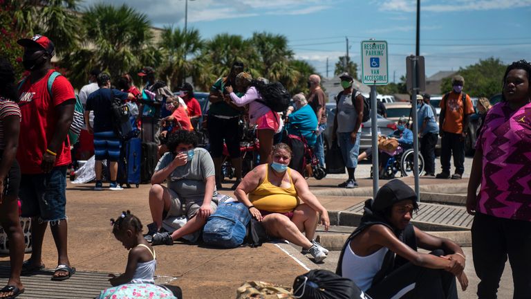 Les gens attendent de monter à bord d'un bus alors que les résidents évacuent avant l'ouragan Laura à Galveston, Texas