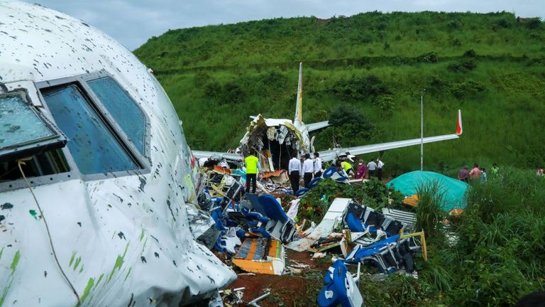Des responsables inspectent l'épave d'un jet Air India Express à l'aéroport international de Calicut