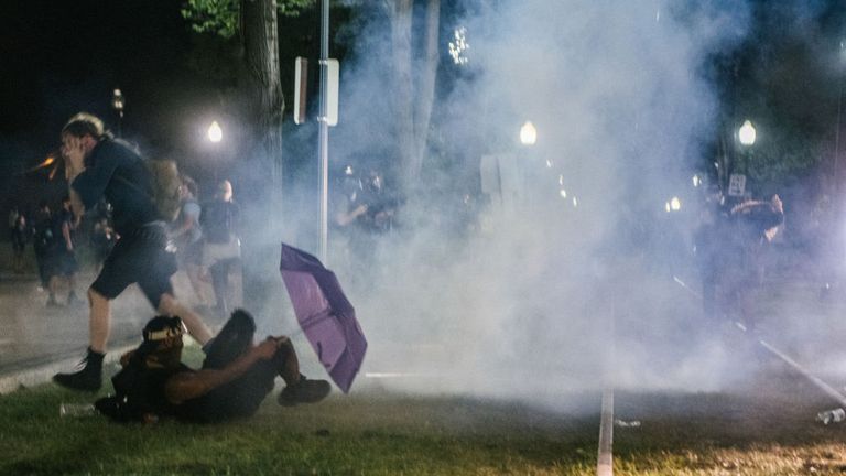 Les manifestants se retirent des gaz lacrymogènes tirés par la police