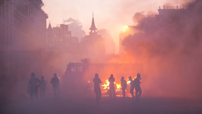 Les manifestants traversent un nuage de gaz lacrymogène