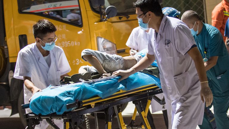 Des travailleurs médicaux transportent un blessé hors des décombres d'un restaurant effondré à Linfen, dans la province du Shanxi, au nord de la Chine