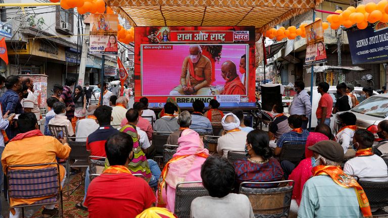 Les gens regardent une projection en direct de la cérémonie de pose de pierre du temple Ram par Narendra Modi à Ayodhya