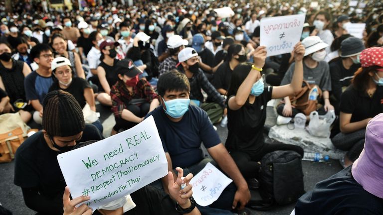 Des manifestants anti-gouvernementaux brandissent des pancartes lors d'un rassemblement au Monument de la démocratie à Bangkok le 16 août 2020. - Les manifestants se sont réunis pour un rassemblement à Bangkok le 16 août contre le gouvernement alors que les tensions montaient dans le royaume après l'arrestation de trois militants à la tête du pro -mouvement démocratique.  (Photo par Lillian SUWANRUMPHA / AFP) (Photo par LILLIAN SUWANRUMPHA / AFP via Getty Images)
