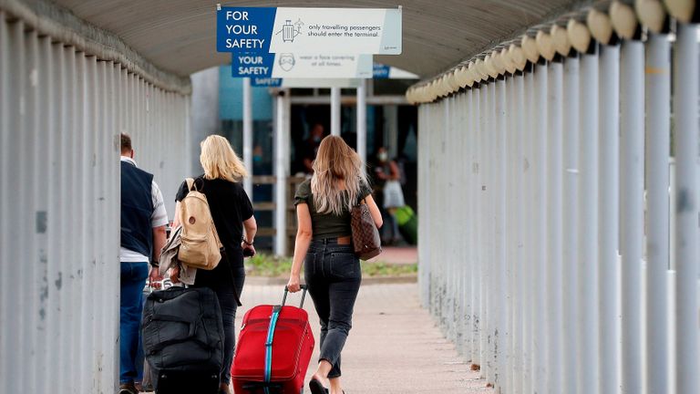 Les voyageurs tirent leurs valises à leur arrivée à l'aéroport de Londres Stansted, au nord-est de Londres, le 20 août 2020, suite à la décision de la compagnie aérienne britannique Easyjet de fermer ses opérations à l'aéroport à partir du 31 août (Photo par Adrian DENNIS / AFP) ( Photo par ADRIAN DENNIS / AFP via Getty Images)