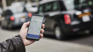 un homme avec l'application Uber ouverte sur son téléphone intelligent