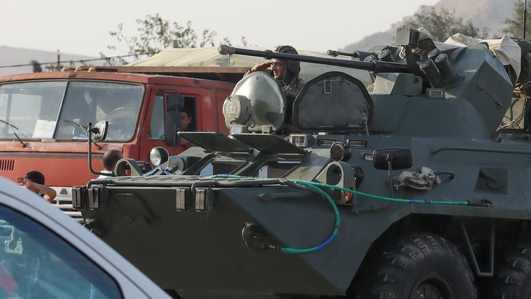 Des gens accueillent dimanche des militaires azerbaïdjanais dans des véhicules militaires à Bakou