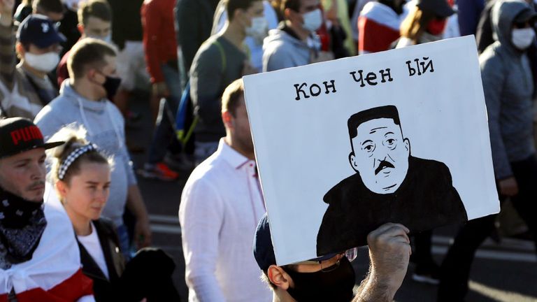 Un homme porte une pancarte représentant le président biélorusse en tant que dirigeant nord-coréen Kim Jong-un et lisant 