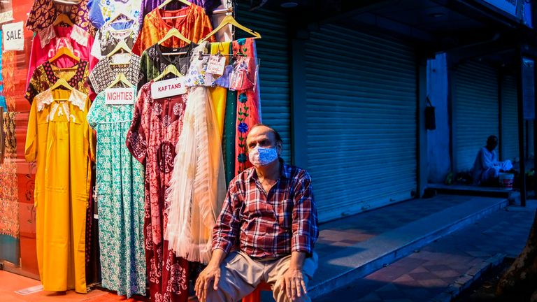 Un homme attend les clients dans son magasin de vêtements à New Delhi 