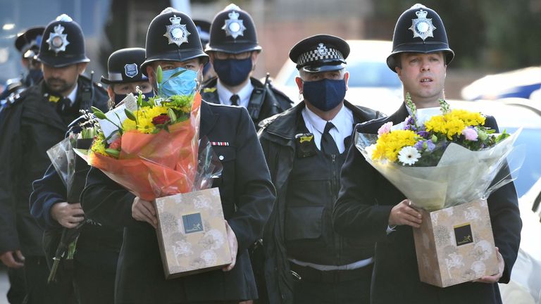 Des officiers du Met portent des fleurs à placer sur les lieux dans le sud de Londres