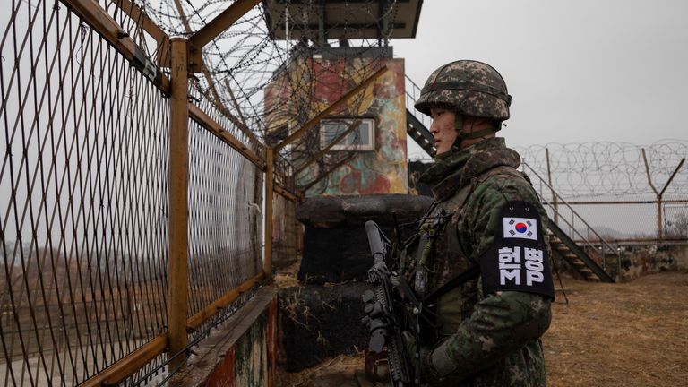 Sur une photo prise le 3 décembre 2018, un soldat sud-coréen se tient devant une clôture de sécurité à un poste de garde à l'intérieur de la zone démilitarisée (DMZ) près de la ligne de démarcation militaire (MDL) séparant la Corée du Nord et la Corée du Sud, dans le comté de Cheorwon en Corée du Sud.