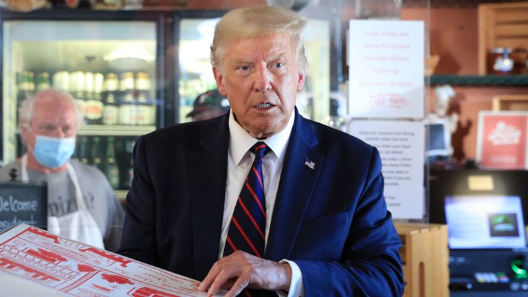 Donald Trump tient une pizza dans une boîte