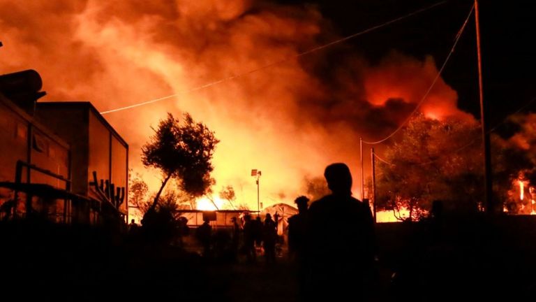 Des migrants partent alors qu'un feu brûle dans le camp de Moria sur l'île de Lesbos le 9 septembre 2020