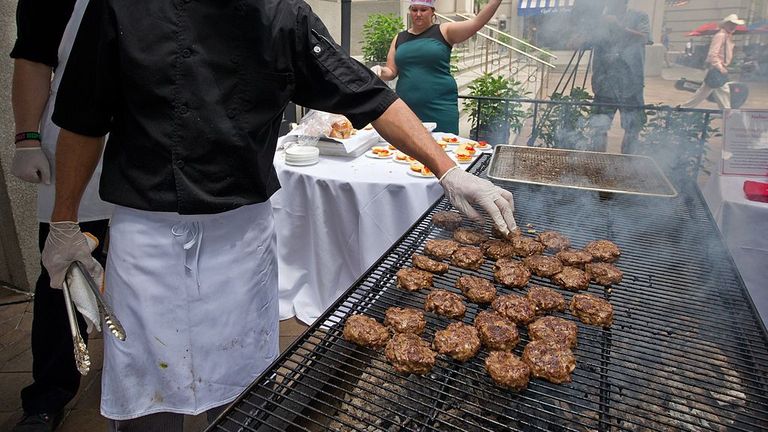 Un cuisinier grille des hamburgers sauterelles le 4 juin 2014 lors d'un événement mondial Pestaurant parrainé par Ehrlich Pest Control, qui a eu lieu à l'Occidental Restaurant à Washington, DC.  Pendant un jour seulement, des Pestaurants pop-up apparaîtront dans les villes du monde entier pour offrir des insectes comestibles sucrés et salés, des hamburgers aux sauterelles et bien plus encore.  Ehrlich Pest Control fera un don de 5 USD à DC Central Kitchen pour chaque personne qui mange quelque chose lors de l'événement.  AFP PHOTO / Karen BLEIER (Crédit photo doit se lire KAREN BLEI