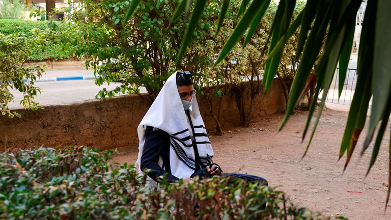 Un juif ultra-orthodoxe prie le long d'une rue devant une synagogue à Bnei Brak, près de Tel Aviv