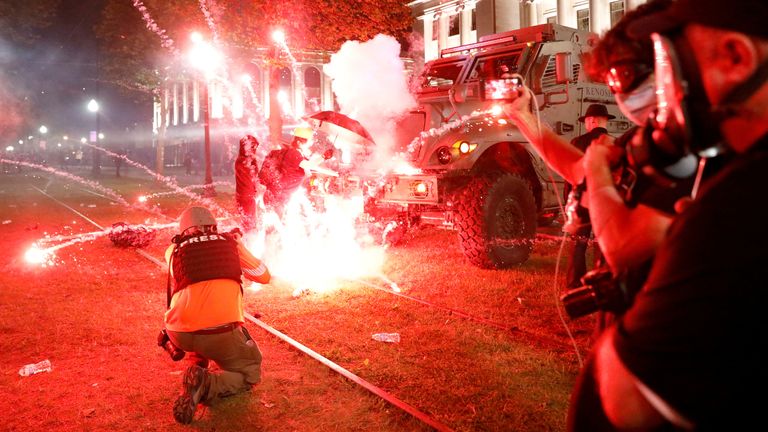 Des fusées éclairantes se déclenchent devant un véhicule du shérif du pays de Kenosha alors que les manifestants participent à une manifestation à la suite de la fusillade par la police de Jacob Blake, un homme noir, à Kenosha, Wisconsin, États-Unis, le 25 août 2020. REUTERS / Brendan McDermid TPX IMAGES DU JOUR