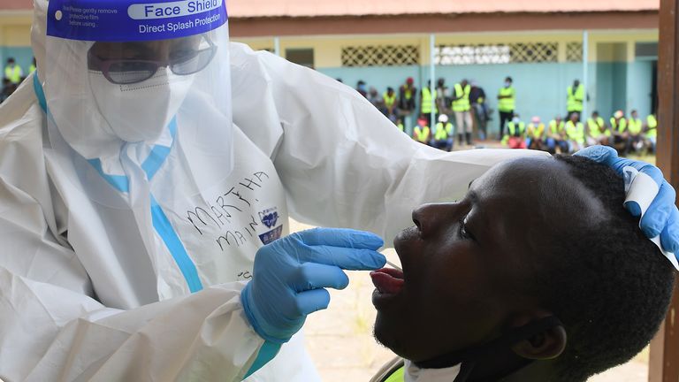 Un agent de santé kényan prélève un écouvillon oral d'un habitant d'Eatstleigh, lors d'un exercice de test de masse du coronavirus COVID-19 à Nairobi le 20 mai 2020