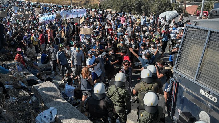 Des migrants manifestant devant un blocus de la police près de la ville de Mytilène