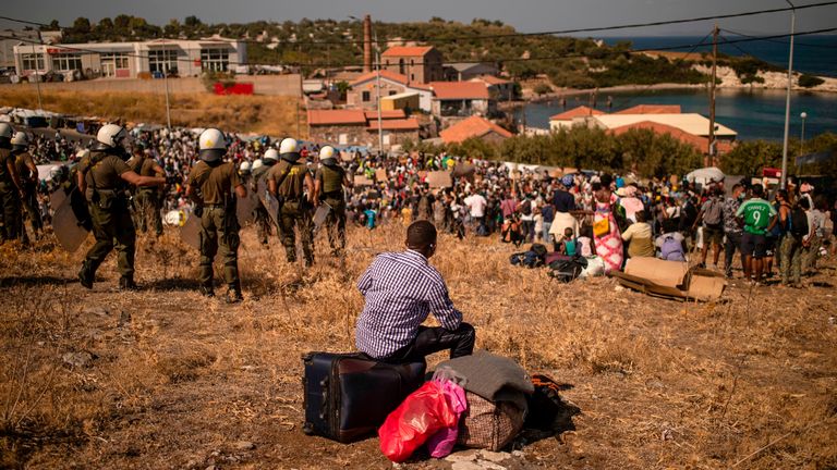 Un migrant est assis sur ses affaires