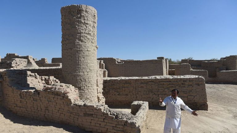 Sur cette photographie prise le 9 février 2017, le gardien pakistanais du site archéologique de Mohenjo Daro, classé au patrimoine mondial de l'UNESCO, Ismail Mugheri, souligne un puits de deux étages utilisé pour collecter de l'eau potable sur le site à quelque 425 km au nord de Karachi.  Autrefois le centre d'une puissante civilisation, Mohenjo Daro était l'une des premières villes du monde - une métropole de l'âge du bronze dotée de toilettes à chasse d'eau et d'un système d'eau et de déchets à la hauteur des normes modernes.  Environ 5000 ans sur les archéologues croient que le ru