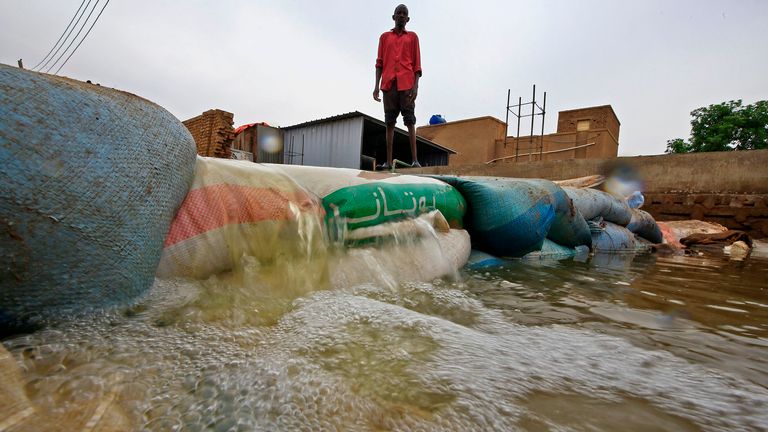 Un Soudanais se tient derrière une barricade au milieu des eaux de crue sur l'île de Tuti, où le Nil bleu et blanc fusionne entre les villes jumelles de la capitale Khartoum et Omdurman, le 3 septembre 2020