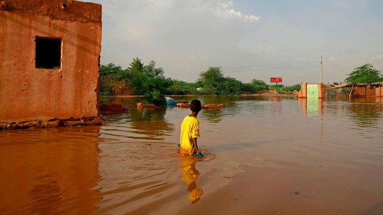   Un garçon soudanais patauge dans une rue inondée du quartier d'al-Qamayir dans la ville jumelle d'Omdurman, la capitale, le 26 août 2020