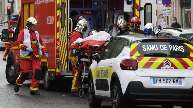 Les pompiers français chargent l'une des nombreuses personnes blessées dans une ambulance en attente près des anciens bureaux du magazine satirique français Charlie Hebdo à la suite d'une attaque présumée d'un homme brandissant un couteau dans la capitale Paris le 25 septembre 2020. - Les menaces coïncident avec le procès de 14 complices présumés des auteurs des massacres à Charlie Hebdo et dans un supermarché juif qui a fait au total 17 morts.  (Photo par Alain JOCARD / AFP) (Photo par ALAIN JOCARD / AFP via Getty Image